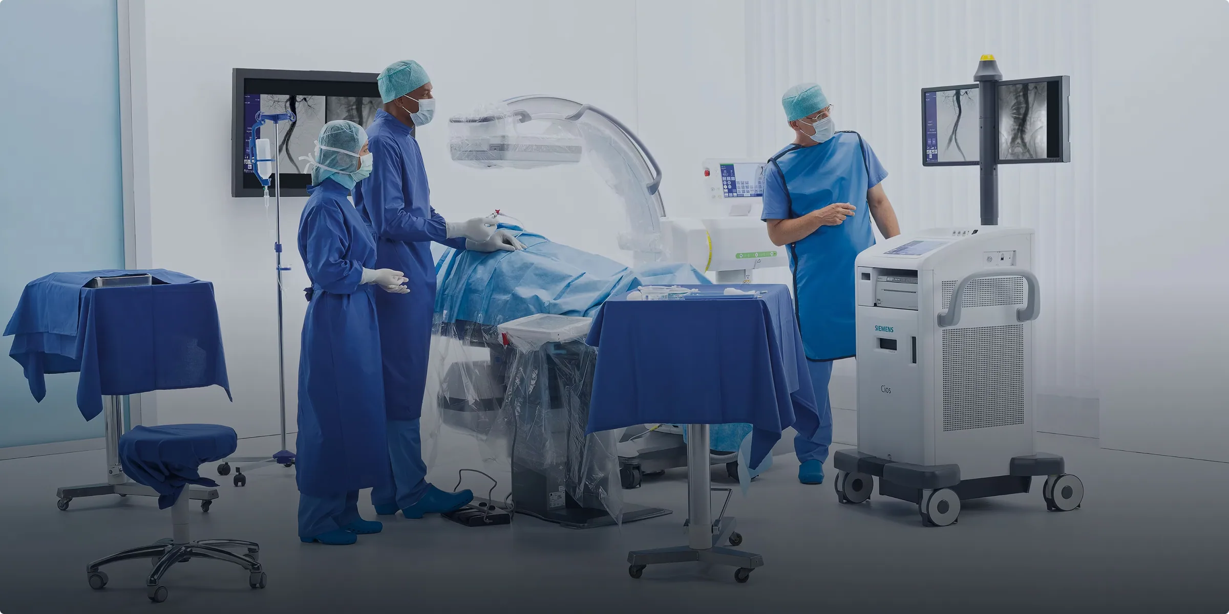 Clinical team using medical imaging equipment in a procedure room